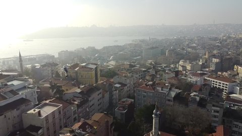 Early morning over Istanbul. Aerial view of the old city centre and Galata Tower. Smoke over the Bosphorus, seagulls in the frame. High quality FullHD footage