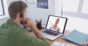 Caucasian man using laptop and phone headset on video call with female colleague. Staying at home in self isolation during quarantine lockdown.