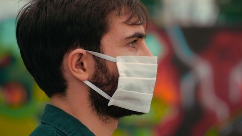 epidemic, contagion - profile of young man with mask looks away