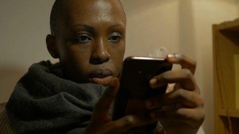 social, communication - black woman reads a message on mobile and hints a smile