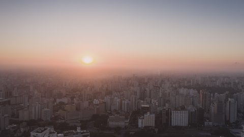 Aerial Hyperlapse of sun rising behind buildings at Sao Paulo city with fog. Sao Paulo, Brazil