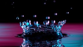 Super slow motion of splashing water crown illuminated by neon lights. Filmed on very high speed camera, 1000 fps. - Powered by Shutterstock - Get 15% off with code: PIKWIZARD15