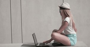 student sitting on the bench using her laptop computer for communicating via the Internet or education