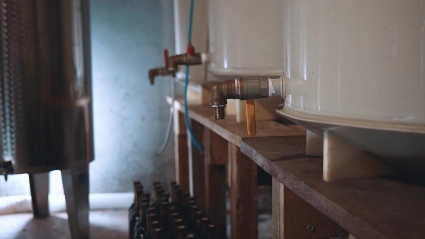 Wine production step by step. Interior of the wine factory. High angle motion camera view at the big metal barrels with taps and wine inside it. Alcohol manufacturing concept
