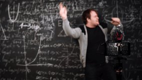 Recreating and dancing teacher is caught by surprise after what he continues online lesson. A professor takes a break during e-learning. A young man stops and blushes. Concept of a distance education. - Powered by Shutterstock - Get 15% off with code: PIKWIZARD15