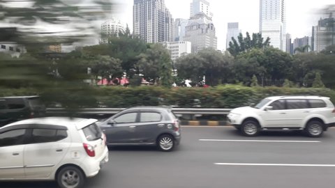 Jakarta, Indonesia - February 2nd, 2021: The traffic condition around 5 PM at Gatot Subroto avenue. The cityscape on the background. View from the bus