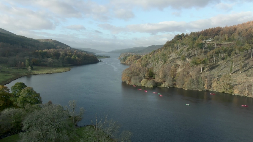 Canoists on Loch Tummel on an autumn morning, Perthshire, Scotland. Flying over the loch towards the canoists.