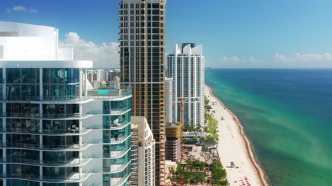 Prestige residential ocean view beach front property USA. Modern buildings. Cinematic aerial Miami beach, Florida. Summer day with copy space on blue background. Real Estate business footage, drone 4K
