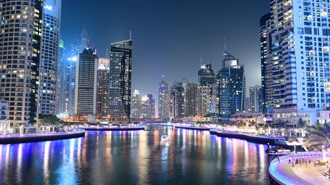 28th JAN, 2021 DUBAI. 4K Timelapse of Dubai Marina skyline with illuminated sky scrappers,buildings and moving boats showing reflection on water captured  from Marina Mall , Dubai, UAE.