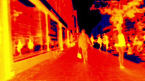 Anonymous passers-by on European street. Scanning the people's body temperature with a thermal imager. It is possible to remotely determine the temperature of healthy and sick people. Blurred