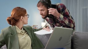 work from home, female office employee works at home online communicating via video link with colleagues while her husband is cleaning in room with vacuum cleaner, looking into camera - Powered by Shutterstock - Get 15% off with code: PIKWIZARD15