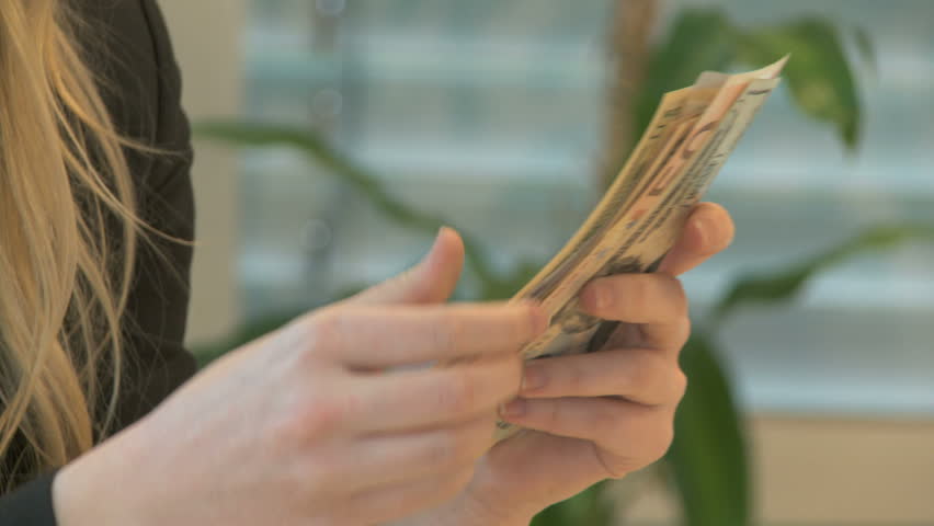 Woman holds bills in her hand and sorts them