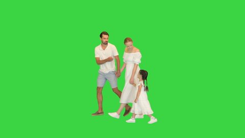Happy parents with their daughter holding hands and walking by on a Green Screen, Chroma Key.