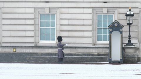 LONDON, UK - FEBRUARY 9, 2021: Soldier Marches through Snow at Buckingham Palace during COVID-19 Lockdown, London, England, UK