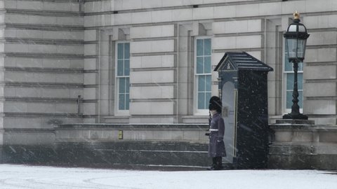 LONDON, UK - FEBRUARY 9, 2021: Soldier Standing in Snow at Buckingham Palace during COVID-19 Lockdown, London, England, UK