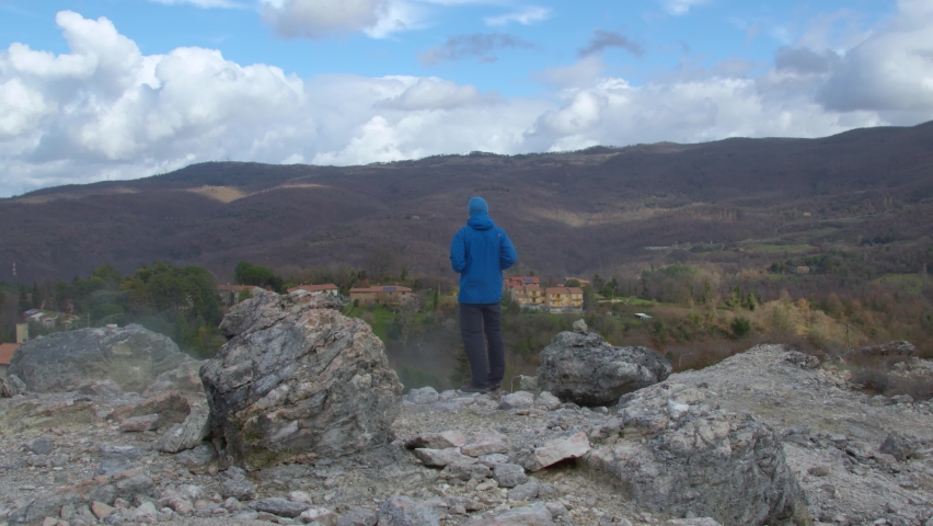 Young man hiker looking landscape panorama tuscany land hills sea cloudy sky
