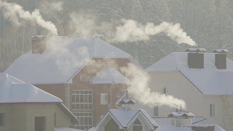 In cold winter weather, smoke comes out of the chimney.