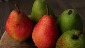 pears on wood table footage.Close-up of green and red pears. fresh pears rotates around its axis.4K video