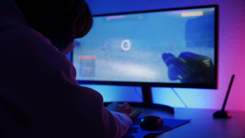 Boy streamer gamer playing shooter online video game - Technology trends concept 