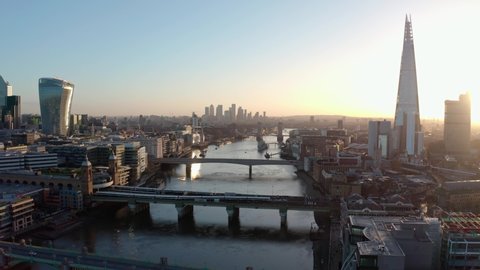Establishing Aerial drone dolly back shot of thames river London city centre sunrise