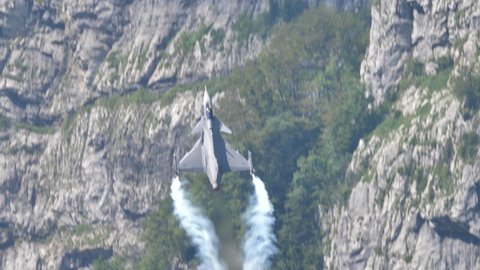Mollis Switzerland 16 August 2019: Impressive vertical climb of a military aircraft with delta wings near a mountain. Saab JAS 39 Gripen combat jet aircraft of Swedish Air Force
