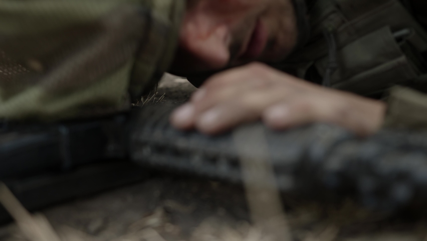 Army infantry soldier carrying his wounded fellow warrior, while another soldier is securing them. Wounded combat soldier is carried to safety.Severely wounded soldier
