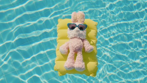 A serious businessman-hare relaxes at the resort. Floats on an inflatable mattress, on it sunglasses