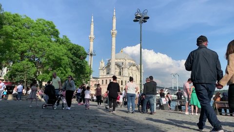ISTANBUL - CIRCA JULY, 2019: Time lapse footage of people on famous, touristic city square called "Ortakoy" in Istanbul. Historical mosque is in the view. It is a sunny summer day.