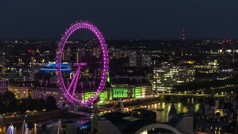 London, Great Britain, circa 2020 - Establishing Aerial View Shot of London UK, Southbank, Lit up London Eye, United Kingdom, night late evening, purple and gold