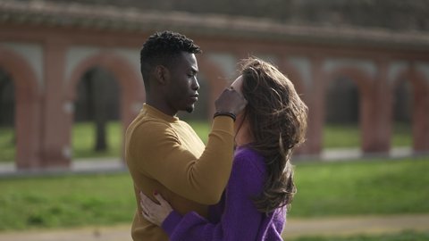 Interracial kiss and hug. Black man with while girlfriend kissing and embrace. love and affection