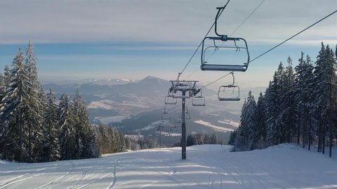 Empty chairlift in closed ski resort due to coronavirus in beautiful sunny winter season in alpine mountains