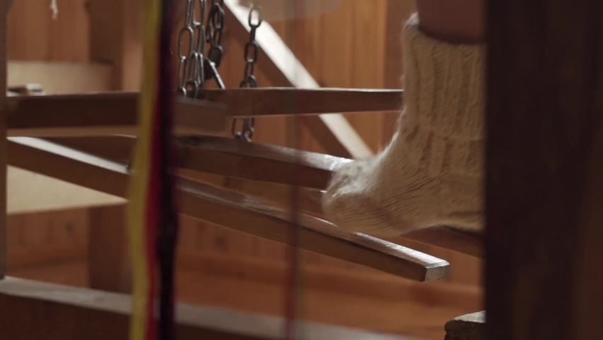 Legs of a woman working on a loom. Ukrainian folk Hutsul art	. Soft focus