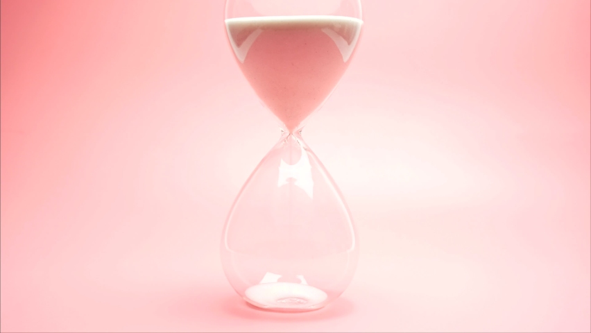 Sand pouring in hourglass on pink background, time pass concept, deadline end. Royalty-Free Stock Footage #1067184415