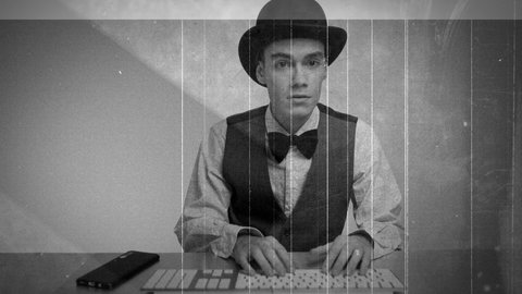 Young businessman in suit using computer keyboard at work with gritty old film overlay: stockvideo