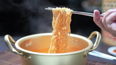 Ramyeon Korean Instant noodles with chopsticks, Hot instant noodles in traditional Korean noodle pot.