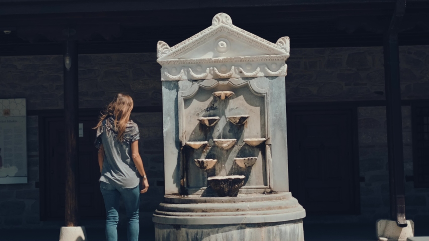 Selsebil fountain in the garden of the Rumi Museum in Konya. woman washing her face in the fountain . slow motion. 4K.
