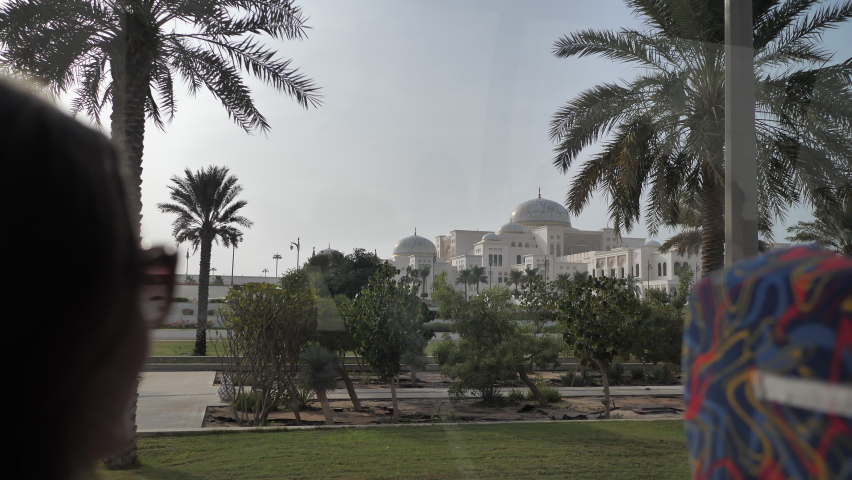 Girl tourist rides on a bus to the palace in Abu Dhabi.