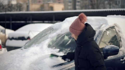Scraping Ice From Glass.Woman Cleaning Car After Snowfall.Brushing Snow And Ice From Car Glass.Female Cleaning Fresh Snow After Snowstorm From Vehicle.Sweep Snow From Automobile With Brushes In Winter