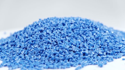 Secondary granule made of polypropylene, Blue Plastic pellets crumbles to the table . Plastic raw materials in granules for industry. Polymer resin. Raw plastic recycling concept.