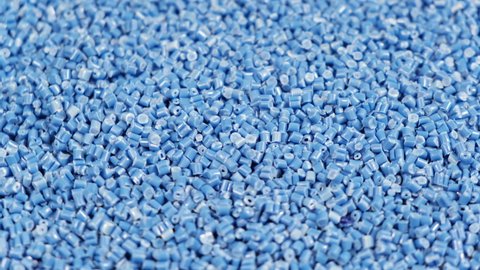 Secondary granule made of polypropylene, Blue Plastic pellets crumbles to the table. Plastic raw materials in granules for industry. Polymer resin. Raw plastic recycling concept.
