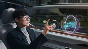 Futuristic Concept: Japanese Businessman Checking Arrival Location on an Interactive Augmented Reality 3D Navigation App while Sitting in on the Back Seat of an Autonomous Self-Driving Car with VFX. - Powered by Shutterstock - Get 15% off with code: PIKWIZARD15