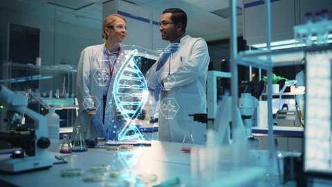 Female and Male Medical Industry Scientists Have Conversation and Use Futuristic Augmented Reality Technological Interface in Modern Science Laboratory. DNA Hologram Appears in Front of Research Team.