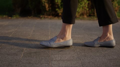 Close-up of business woman legs running. Mature girl walking on the asphalt of a city street. Business concept, office employee. High quality 4k footage
