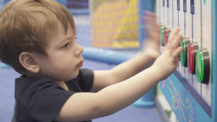 Child presses keys on a musical apparatus in an amusement park