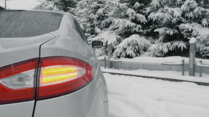 Car gets stuck in the snow. Vehicle is stopped on the side of the road with hazard lights on. Carriageway is covered with snow. Car flashing rear hazard warning lights in close up | Shutterstock HD Video #1067218090