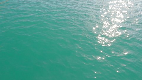 Bright shiny sun glare reflection on deep blue sea water surface n calm cyan ocean wave or ripple in tropical summer or spring sunlight n sunray in sunny day, 4k cinemagraphs b-roll video footage