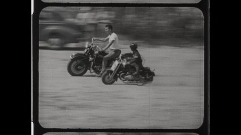 1950s Sturgis, SD. Father and Son ride Motorcycles together. The Young Boy rides a Chopper with his Dad, Father Son Bonding. 4K Overscan of Vintage Archival 16mm Film Print