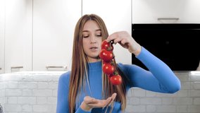healthy lifestyle. online nutritionist. beautiful woman shoots video about healthy food in kitchen at home. she stands in front of camera and talking about healthy diet. Vlogging and social media.