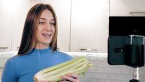 healthy lifestyle. healthy food. online nutritionist. beautiful woman shoots video with smartphone in kitchen at home. she stands in front of camera and talking about healthy diet. Vlogging and social