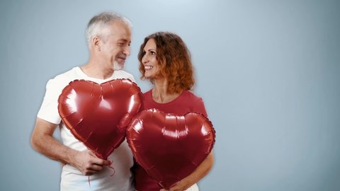 Mature couple in casual attire celebrating Valentine's Day, anniversary